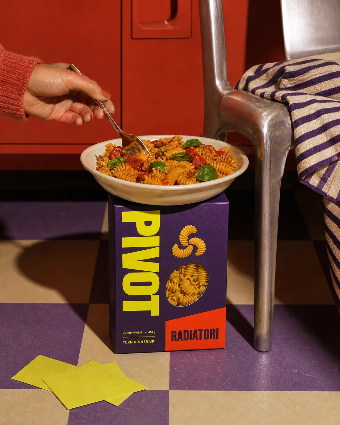 Escena cotidiana de PIVOTE con plato de pasta y packaging en una cena informal